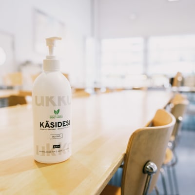 Käsidesi pullo kouluruokalassa.
