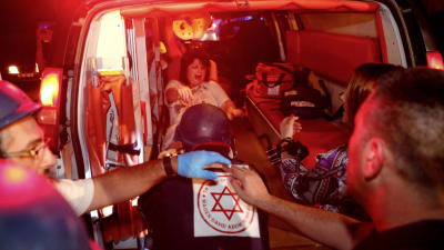 En skadad israelisk kvinna, vars hus i Ashkelon träffats av en raket, fördes till sjukhuset med ambulans. 