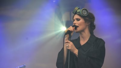 Sångaren Nina Persson uppträder på en lilafärgad scen på Rusrock.