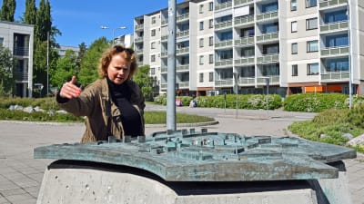 Laura Kolbe står vid en miniatyr av stadsdelen Rönnbacka.