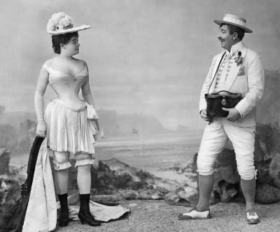 En kvinna i korsettunderkläder och hatt och en amatörfotograf tidigt 1900-tal.