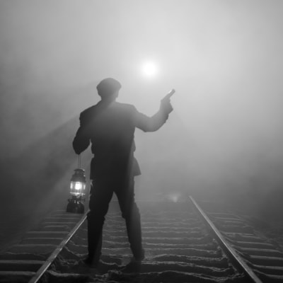 Pojke står med en stormlykta och en pistol och stannar ett annalkande tåg. Iscensatt bild för dokumentären.