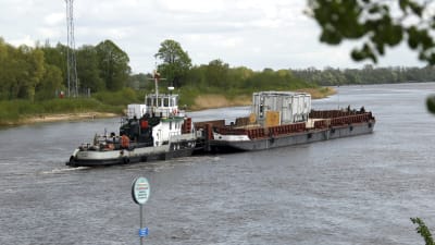 En pråm lastad med Baltikums ny största autotransformator flyter upp för floden Njemen mot Alytus i södra Litauen.