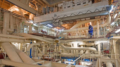 Bilden tagen inne i det flytande kärnkraftverket. På bilden syns en person och en massa rör i olika våningar.