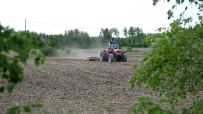 En traktor kör omkring på en åker.