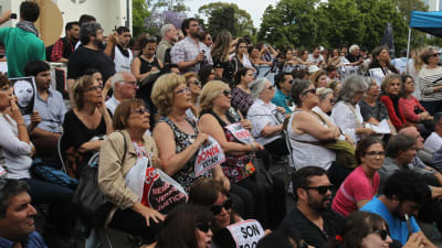 Folksamling utanför domstolsbyggnaden i Buenos Aires väntar på att föra höra domen mot flera tidigare officerare som åtalas för tortyr och mord under militärjuntans tid vid makten.
