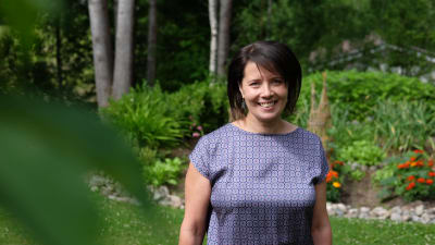 Hanne Aho står i sin trädgård.