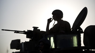 Silhouett av en israelisk soldat som sticker upp ur en stridsvagn.