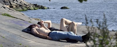 Solande par på en klippa vid havet i Helsingfors. 
