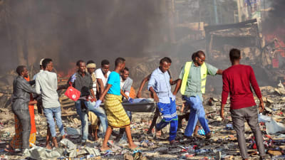 Män bär på en bår med ett av offren för bombdådet utanför hotel Safari i Mogadishu på lördagen.