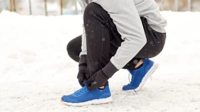 Person med låga skor och bar vrist i snön. 