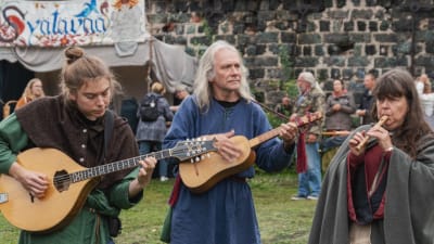Kolme muusikkoa soittaa soittimiaan keskiaikamarkkinoilla keskiaikaiset vaatteet yllään.