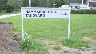 Skylt där det står tandvård på gräsmatta.