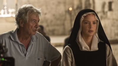 Regissören Paul Verhoeven står bredvid skådespelaren Virginie Efira som är klädd som nunna, under inspelningen av filmen Benedetta.