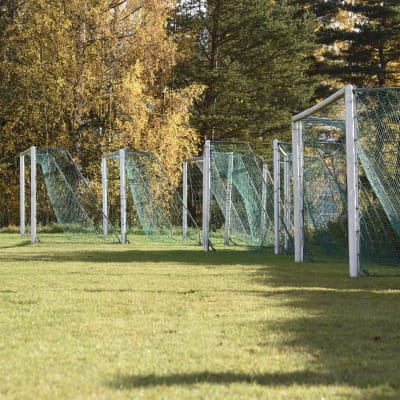 Sju fotbollsmål står på en gräsplan.