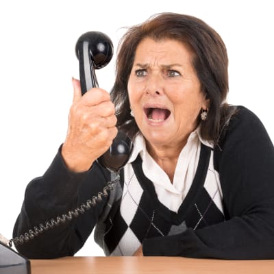 Arg kvinna skriker i telefonen.