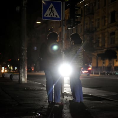 Ihmisiä pimeällä kadulla Kiovassa.