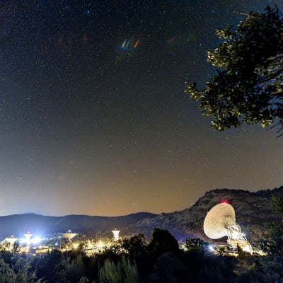 Radioteleskooppeja erottuu valoissa tähtitaivaan alla.