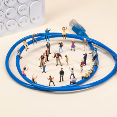 Leksaksfigurer uppställda i ring vid en internet-kabel.