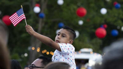 En pojke viftar med USA:s flagga.
