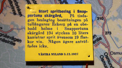 En gul textruta på en karta. I rutan text från en artikel i Västra Nyland 3.12 1927 med rubriken "Stort spritbeslag i Snappertuna skärgård".
