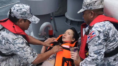 Thailändska marinsoldater hjälper en turist som befann sig ombord på båten som förliste utanför Phukets kust.