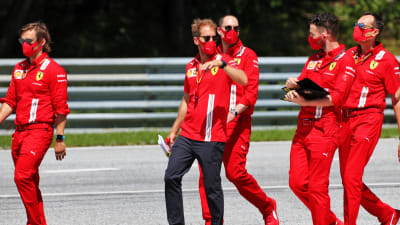 Sebastian Vettel (i svarta byxor) inspekterar banan i Österrike tillsammans med Ferraris personal.