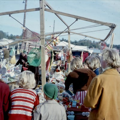 Människor trängs vid ett marknadsstånd.