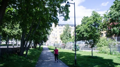 Kvinna promenerar/motionerar nära eira stranden på sommaren.
