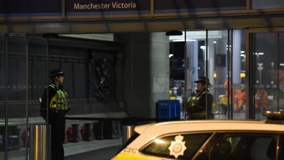 Poliser och en polisbil utanför tågstationen Manchester Victoria efter knivattacken på nyårsafton.