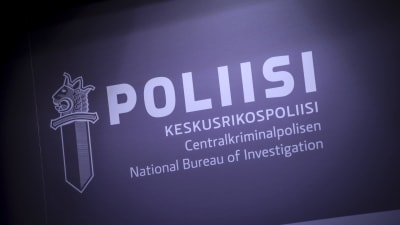 En skylt med polisens logo som föreställer ett svärd med det finska lejonhuvudet. Previd logon ses texten "Polis" och "Centralkriminalpolisen"
