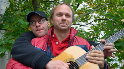Marcus Granberg håller i gitarren medan Tomas Nyberg skojsamt spelar på den.
