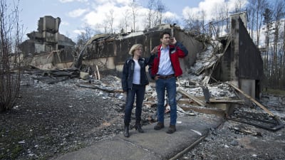 Provinsen Albertas premiärminister Rachel Notley (tv) och Kanadas premiärminister Justin Trudeau (th) inspekterar skadorna i Fort McMurray.