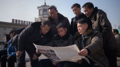 Folk läser tidning efter misslyckat toppmöte i Hanoi