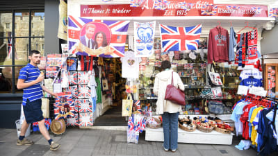 Bild på utsidan av en butik som säljer souvenirer prydda med det kungliga paret.