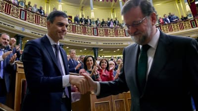 Spaniens avgående premiärminister Mariano Rajoy skakar hand med den nya premiärminister Pedro Sanchez.
