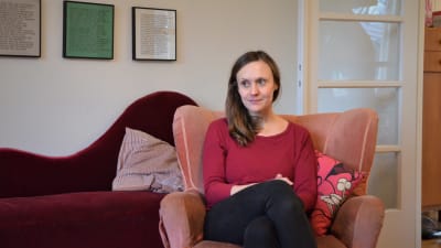 Monica Ålgars sitter i en ljusröd fåtölj. 
