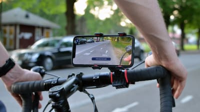 En smarttelefon på en cykelstång filmar cykelvägen framför cykeln.