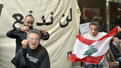 Arga demonstranter har tagit på sig masker med den korruptionsmisstänkta centralbankschefen Riad Salamehs ansikte under en protest i Beirut.