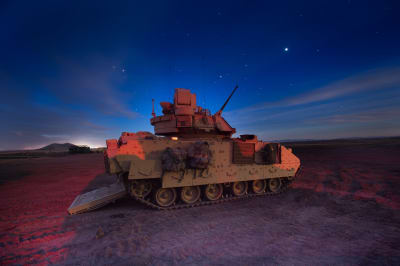 Bradley-stridsvagn under natthimlen.