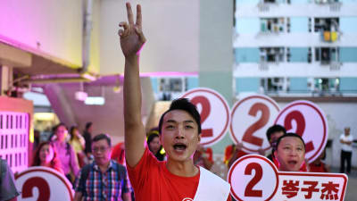 Oppositionskandidat i Hongkong firar genom att visa fredstecknet med sina fingrar.