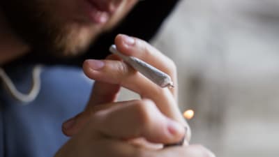 Man håller i tändare och marijuana