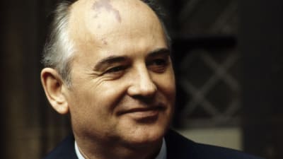 En leende Michail Gorbatjov i mörblå kostym. 