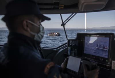 Turkisk gränsbevakare i en båt spanar in en flyktingbåt.