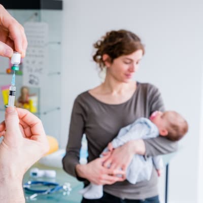En läkare förbereder vaccinationsspruta för en baby.