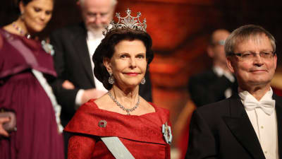 Drottning Silvia och Carl-Henrik Heldin, ordförande för Nobelstiftelsen, anländer till Nobelbanketten 2015.