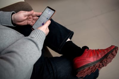 En person sitter med Coronablinkern öppen i en mobiltelefon.  