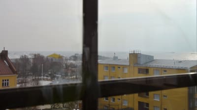 Foto taget från fastigheten Mau-Mau i Hangö. På bilden syns spaet på Fabriksudden och ett stort gult flervåningshus. I bakgrunden skymtar det öppna havet.