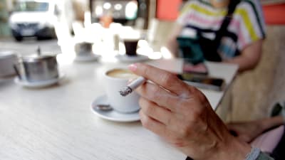 En kvinna som röker på ett café i La Coruna, i galicien, Spanien 13.8.2020.