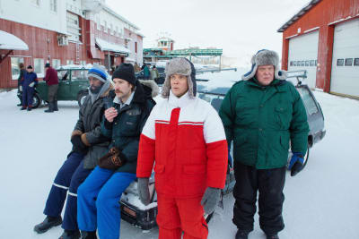 Kaksi miestä istuu henkilöauton konepellillä tupakalla. Edessä seisoo kaksi miestä talvivaatteissa.